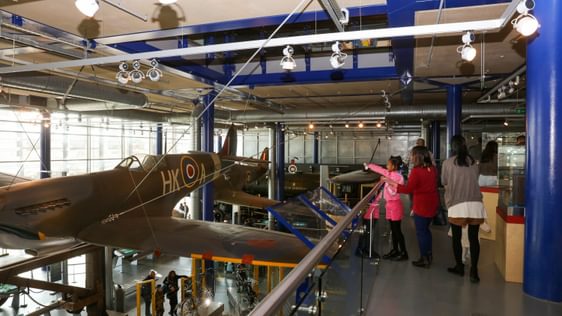 Family looking at a Spitfire plane suspended in the air.