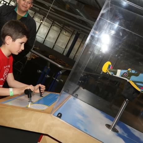 A child playing with an interactive toy spitfire plane.
