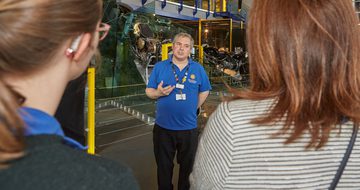 A staff member talking to two people
