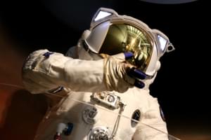 Close up of top half of astronaut suit, the helmet has a mirrored visor