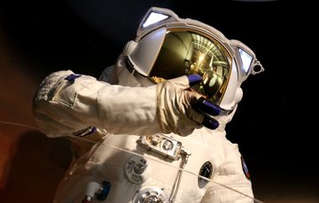 Close up of top half of astronaut suit, the helmet has a mirrored visor