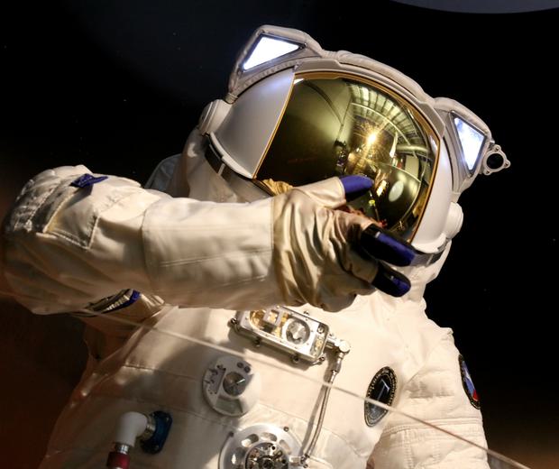 Close up of top half of astronaut suit, the helmet has a mirrored visor