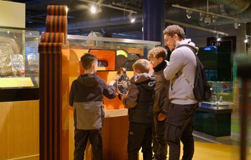 Three children interact with an exhibit in a the gallery.