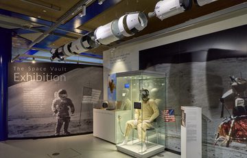 Wide angle view of the exhibition with introduction panel, space suit and large photo graphics.