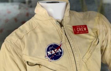 Close up of the neck and shoulders area of a flight suit on display.