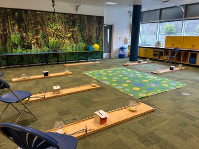 A classroom space with mats and objects laid out on the floor.