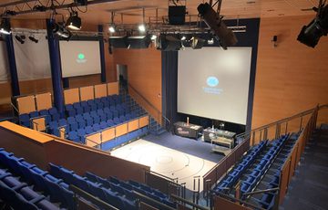 An empty theatre space with seating on three sides.