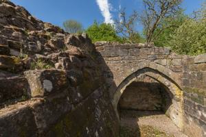 Close view of two ruined castle walls joined by a pointed stone arch