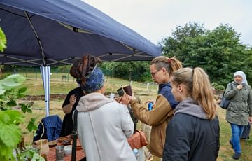 People looking at a person holding a medieval cup.