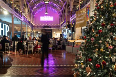 Festive indoor dining with Christmas tree, decorated high ceilings, and neon "Made in Birmingham" sign.