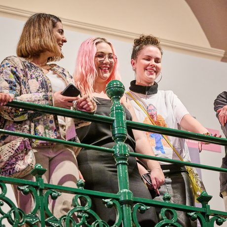 A group of people on a balcony they are smiling.