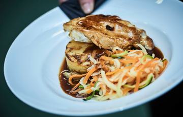 A dish of chicken, gravy and shredded vegetables.