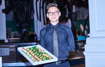 A waiter serving canapés on a tray.