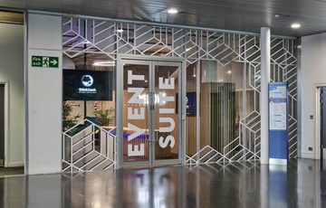 Glass entrance doors with 'Event Suite' on them and a modern geometric design.