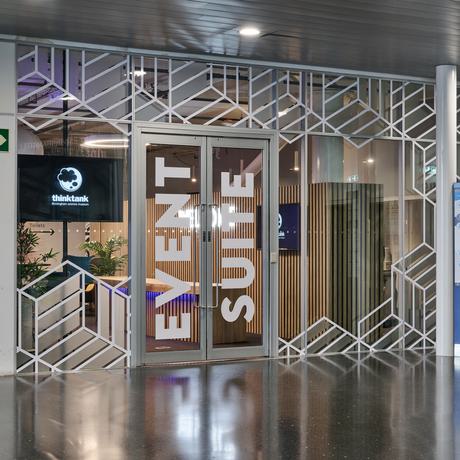 Glass entrance doors with 'Event Suite' on them and a modern geometric design.