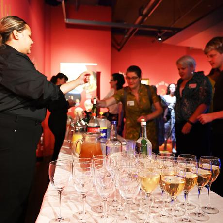 A waitress serving drinks from a table to visitors.