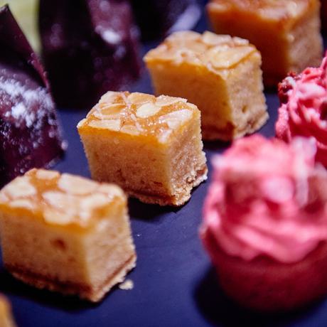 Close up of pink, purple and orange mini desserts.