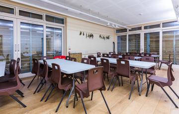 Inside the event space set up with four rows of tables and chairs.