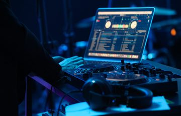 A close up shot of a DJ deck, the lighting is dark and blue.