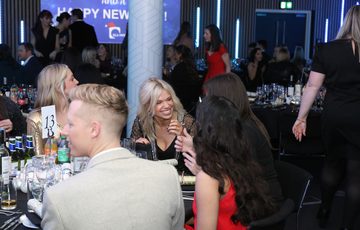 A group of people at a dinner table smiling.
