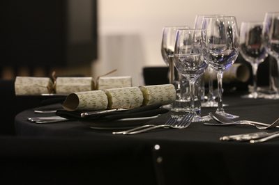 Close up of a table laid out with glasses, cutlery and crackers.